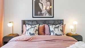 A bedroom with a bed, two bedside tables, a framed picture on the wall, and a zebra-patterned pillow. - Brand New Tampa Townhouse Prime Location (Tampa)
