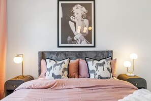 A bedroom with a bed, two bedside tables, a framed picture on the wall, and a zebra-patterned pillow. - Brand New Tampa Townhouse Prime Location (Tampa)