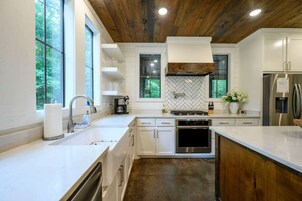 Una cocina moderna con armarios blancos, horno de acero inoxidable y una isla grande.