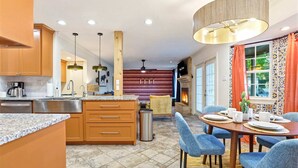 A modern kitchen with granite countertops, wooden cabinets, and a central island. - Elegant Escape Sleeps 14 Games Pool Fire Pit (San Antonio)