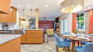 A modern kitchen with granite countertops, wooden cabinets, and a central island.