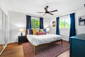 A bedroom with a bed, two bedside tables, a ceiling fan, and a window with curtains. - Elegant Escape Sleeps 14 Games Pool Fire Pit (San Antonio)