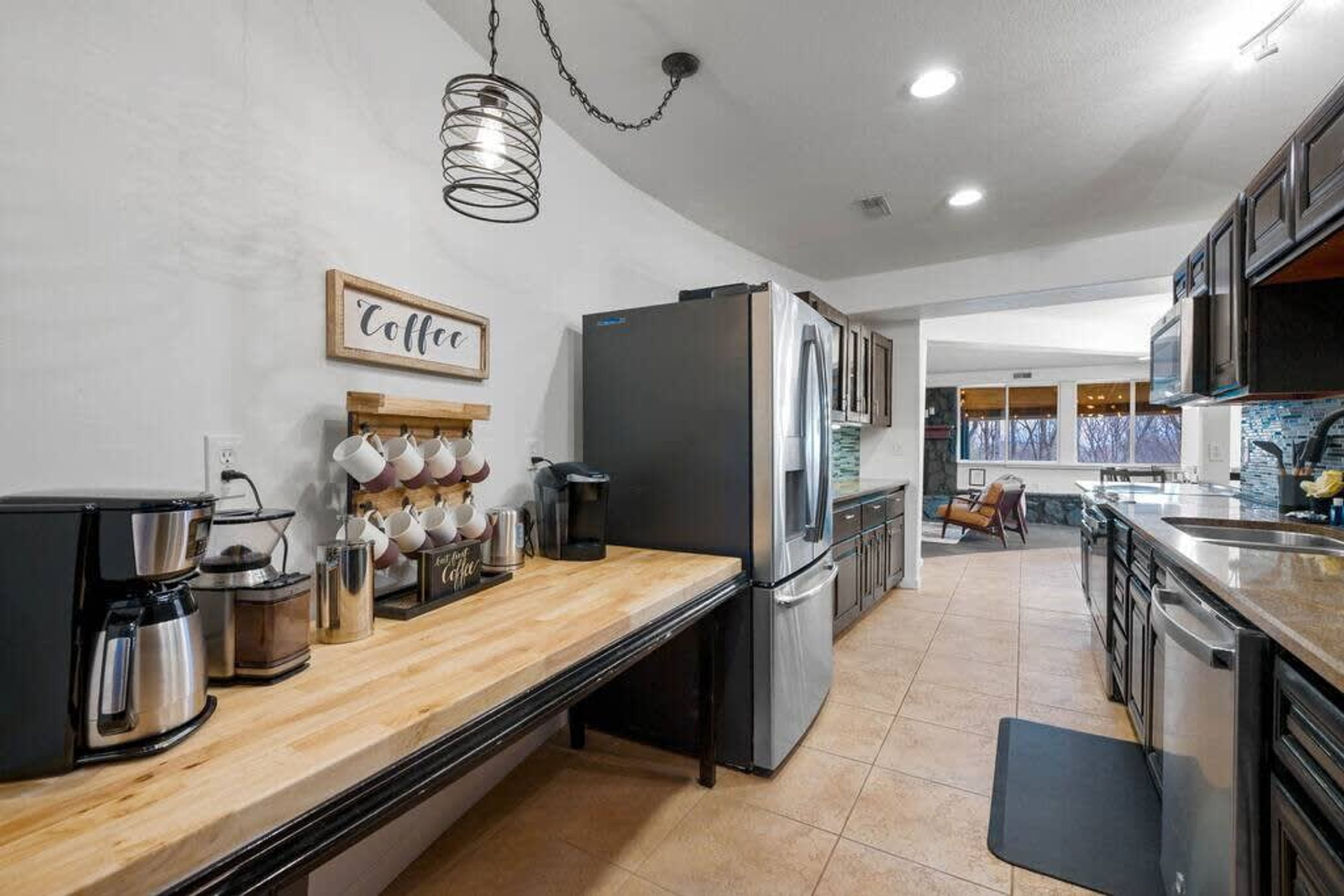 A modern kitchen with stainless steel appliances, a wooden countertop, and a coffee-themed decor.