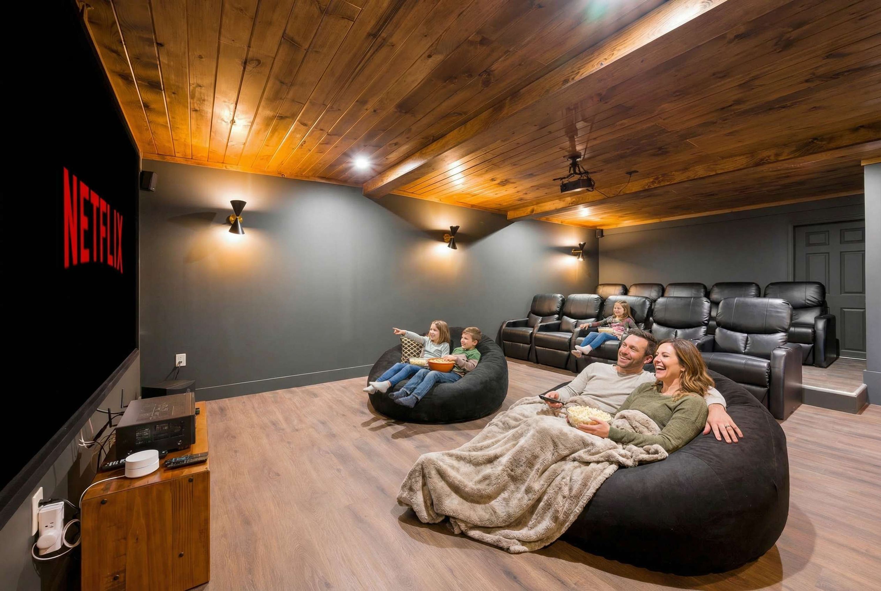 A home theater room with a Netflix logo, a wooden ceiling, and black leather seating.