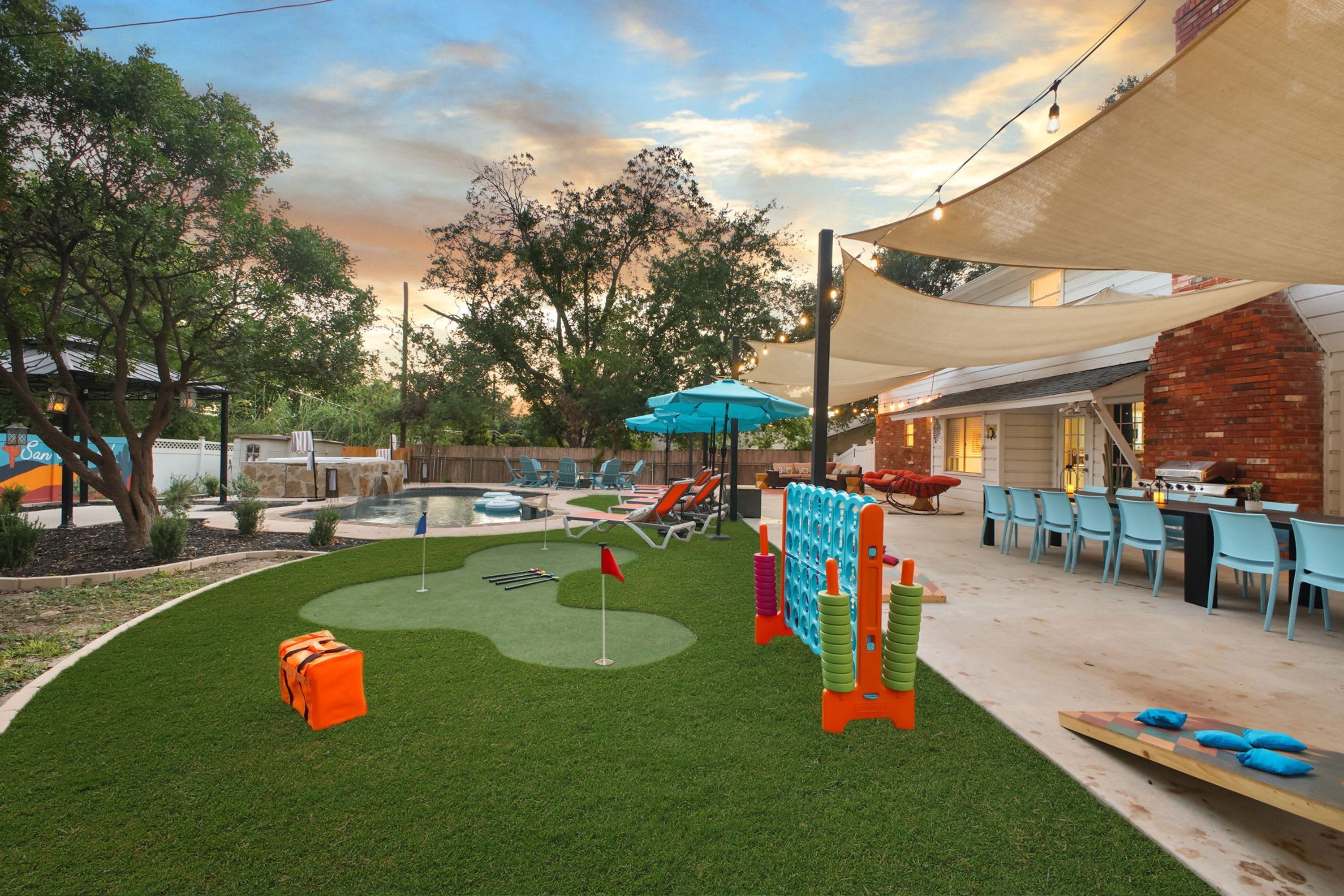 Un jardin avec un terrain d’entraînement au golf, un espace salon extérieur et un coin barbecue.