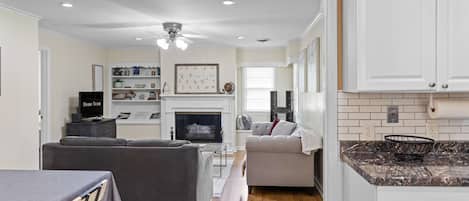 A modern living room with a fireplace, a television, and a seating area.