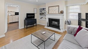 Una sala de estar con chimenea, televisor y sofá.