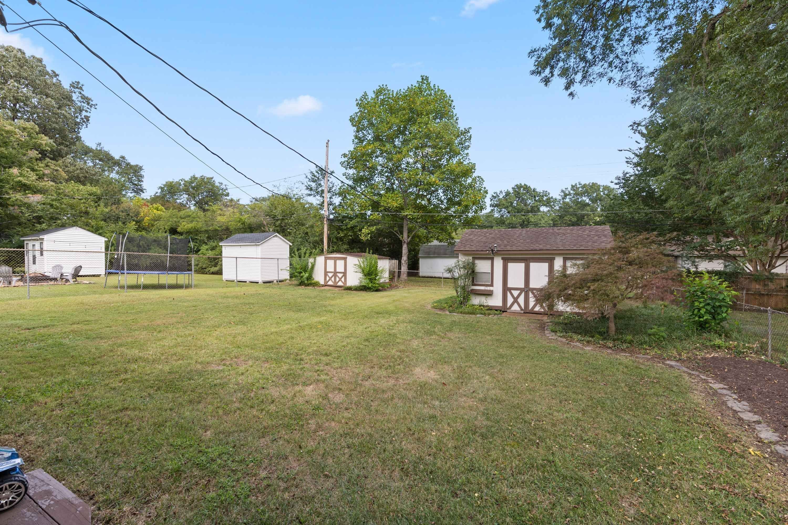 A residential area with multiple small houses, a grassy yard, and a tree.