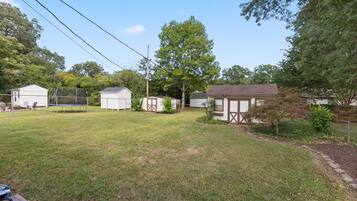 A residential area with multiple small houses, a grassy yard, and a tree.
