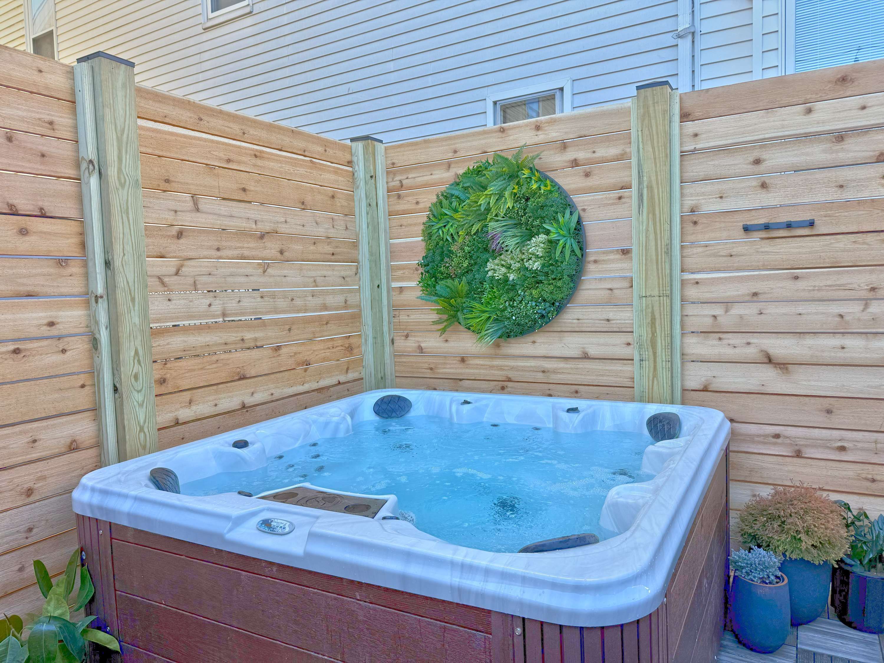 Een hottub met een houten omheining en een krans.