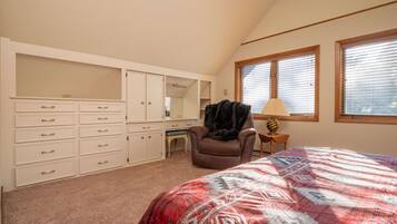 A bedroom with a bed, a desk, a chair, and a wardrobe.