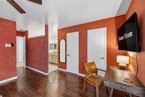 A modern interior with a dining area, a TV mounted on the wall, and a ceiling fan. - Honky Tonk Dreams Pool - Hot Tub - Games (San Antonio)
