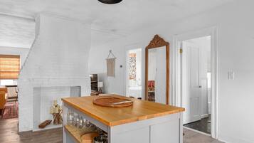 A kitchen with a wooden countertop, a hanging macrame wall decoration, and a large mirror.