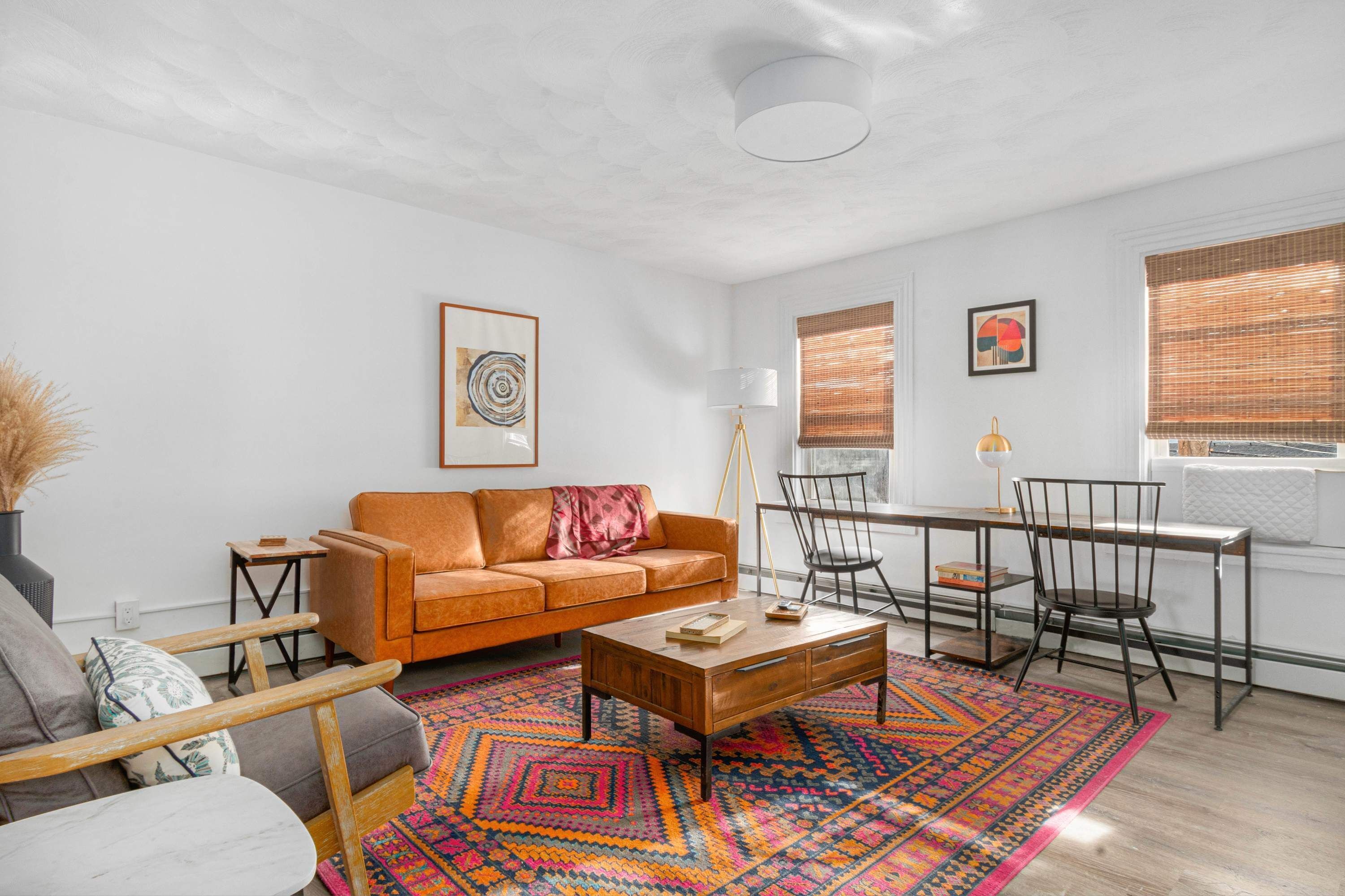 Un salon avec un canapé, une table basse et un tapis à motifs.