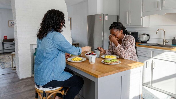 Una cocina moderna con una isla central, electrodomésticos de acero inoxidable y armarios blancos.