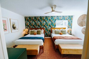 A hotel room with two beds, a ceiling fan, a patterned wall, and a small table with a lamp. - Sleeps 10 Outdoor Oasis Heated Pool Grill (Bradenton)