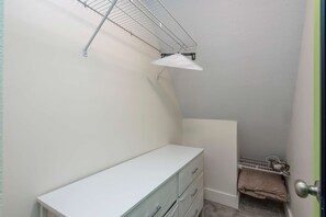 A small, enclosed room with a white dresser, a metal shelf, and a door with a round handle. - New Stargazing Dome Hot Tub Sauna Firepit (Asheville)