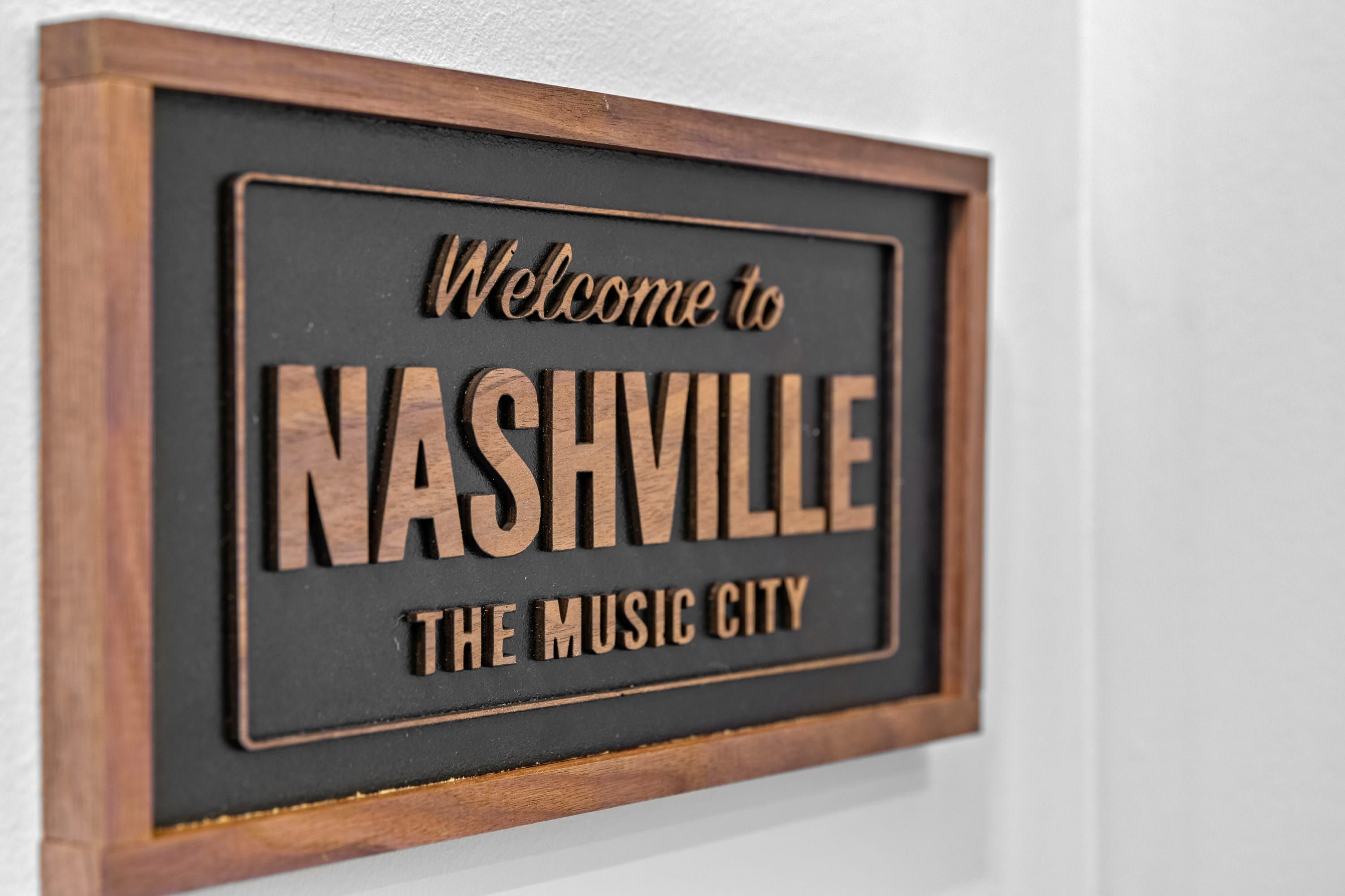 A welcome sign for Nashville, the music city, framed in wood.