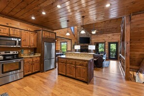 A spacious kitchen with wooden cabinets, stainless steel appliances, and a large island. - EZ Come EZ Geaux - Stunning Mtn Views - Hot Tub (Blue Ridge)