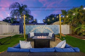 An outdoor patio with a fire pit, a sofa, and a hammock. - Tropical Tee - Putt Putt - Pool - Hot Tub - Bikes (Largo)