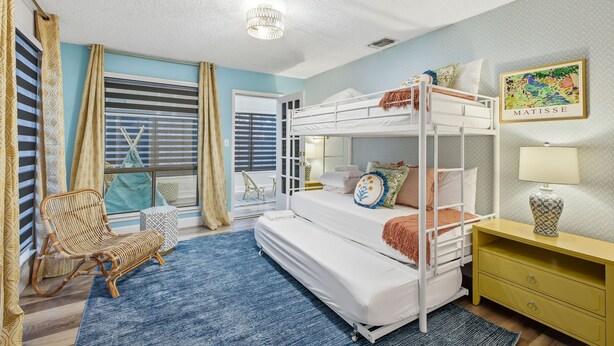 A bunk bed room with a window, a chair, a lamp, and a small table. - Riverwalk Villa Game Room Grill Heated Pool (San Antonio)