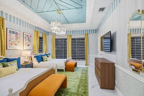 A bedroom with a bed, bedside tables, a dresser, a mirror, and a chandelier. - Riverwalk Villa Game Room Grill Heated Pool (San Antonio)