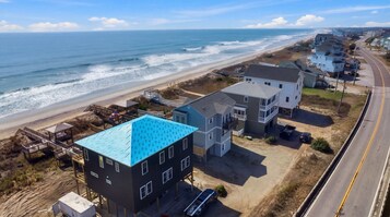 Zona residencial costera con casas, playa y una carretera.