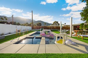 Ein Garten mit Pool, einem pinken Luftauto und einem kleinen Schlauchboot.