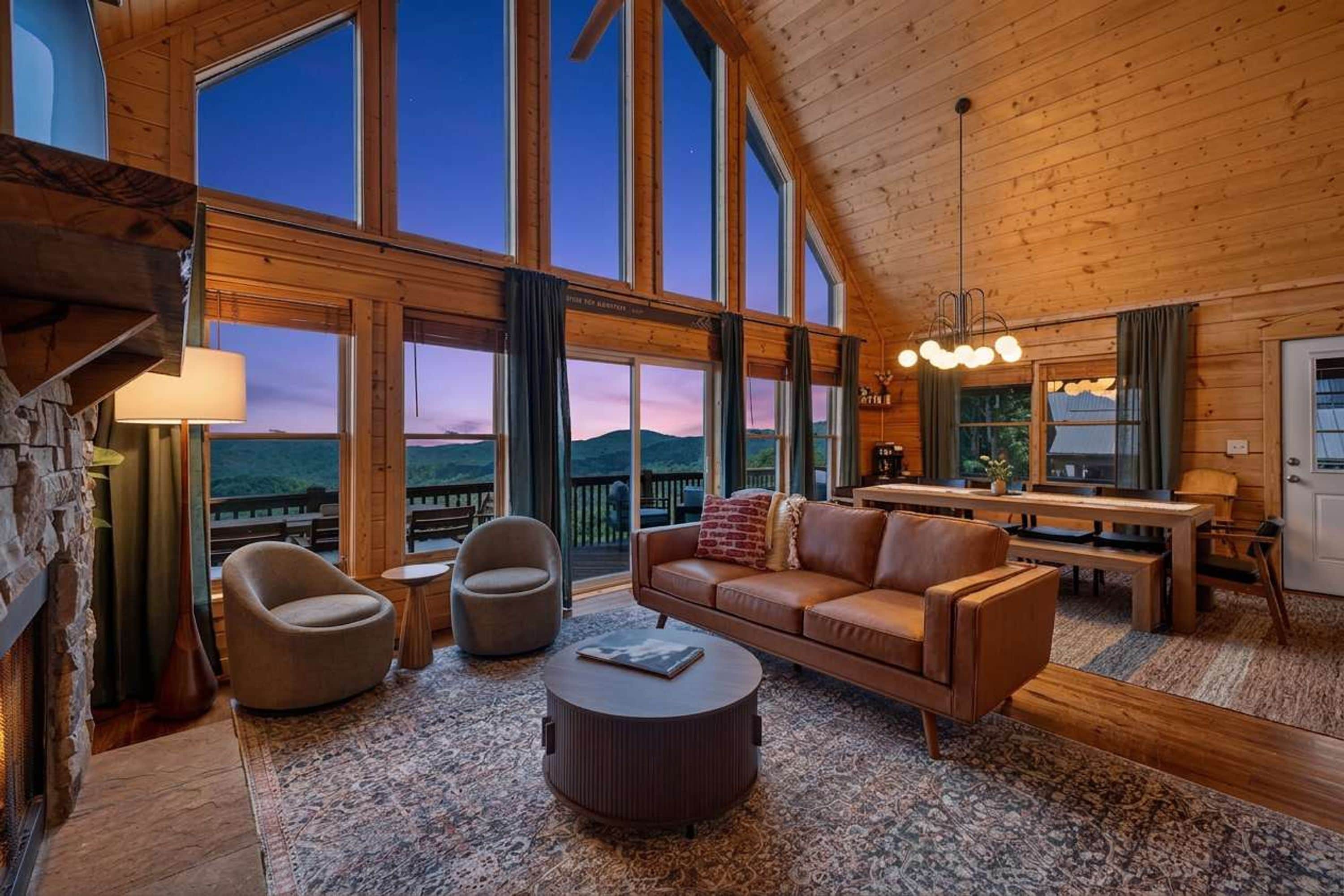 A spacious living area with a large window, a fireplace, and a cozy seating arrangement.