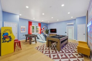 Ein Zimmer mit Poolbillard, Kicker und einem Fernseher, der 'NETFLIX' anzeigt.