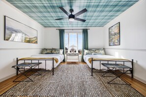 A room with two beds, a ceiling fan, and artwork on the walls. - Luxury Mtn Retreat Hot Tub Sleeps 18 Game Room (Asheville)