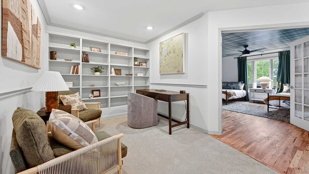 A spacious living room with a large bookshelf, a comfortable seating area with a sofa and armchairs, and a view into a bedroom with a bed and a window. - Luxury Mtn Retreat Hot Tub Sleeps 18 Game Room (Asheville)
