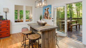 A modern kitchen with a wooden island, bar stools, and a cow skull decoration. - Mountain Views Hot Tub Firepit Game Room (Asheville)
