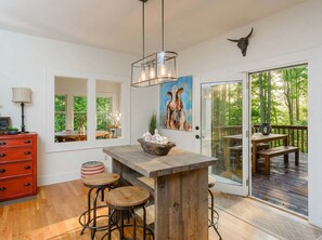 A modern kitchen with a wooden island, bar stools, and a cow skull decoration. - Mountain Views Hot Tub Firepit Game Room (Asheville)