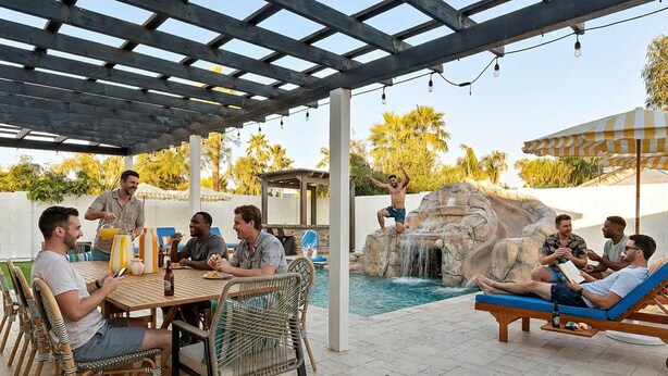 Un'area patio esterna con piscina, tavolo da pranzo e poltrone relax.
