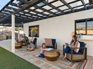 A covered patio area with seating, a pool, and a view of the outdoors. - The Desert Daydream Heated Pool Water Slide (Scottsdale)