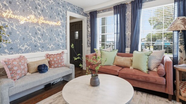 A living room with a floral wallpaper, a sofa, a loveseat, a coffee table, and a chandelier. - Charming Savannah Getaway Hot Tub Sleeps 8 (Savannah)