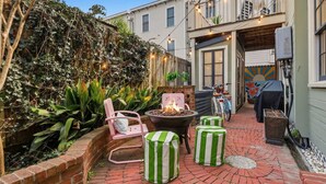 A brick patio with outdoor seating, a fire pit, and a bicycle. - Charming Savannah Getaway Hot Tub Sleeps 8 (Savannah)