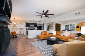 A modern living room with a sectional sofa, a coffee table, and a fireplace. - Giddy Up Getaway Pool Hot Tub Family Fun (San Antonio)