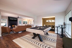 A modern living room with a pool table, a fireplace, and a cozy seating area. - Giddy Up Getaway Pool Hot Tub Family Fun (San Antonio)