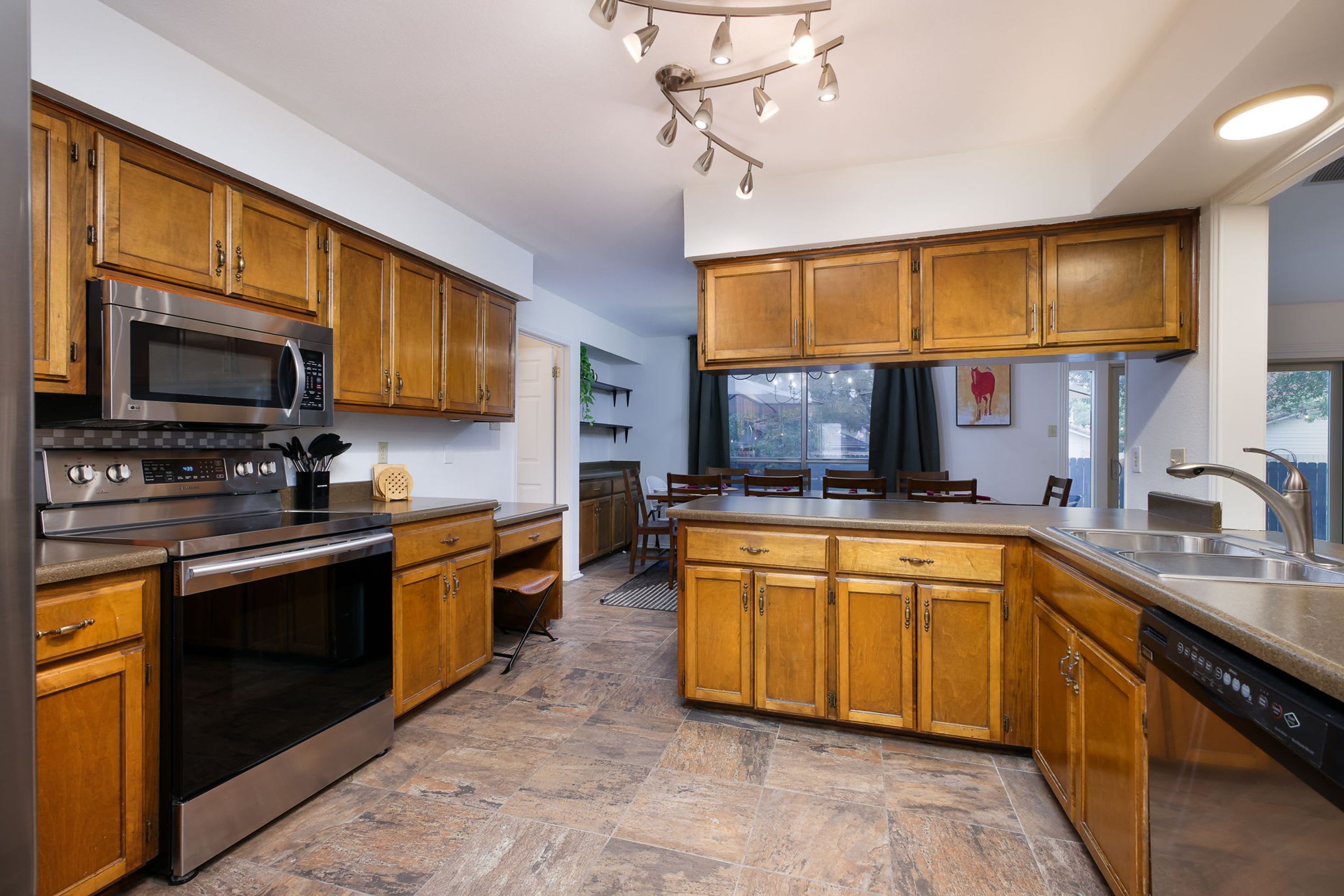 Una cocina con armarios de madera, electrodomésticos de acero inoxidable y una isla central.