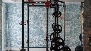 Ein Heimfitnessraum mit Squat-Rack, Langhantel und Gewichtsplatten.