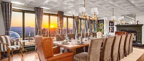 Un comedor con una mesa grande, sillas y vistas al exterior.