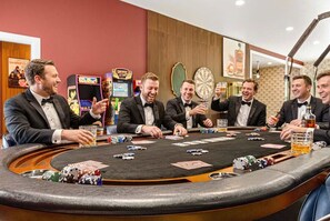 A group of men at a casino table with poker chips and playing cards. - 14k sq ft Mountaintop Estate - Private Golf Course (Fletcher)
