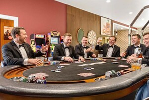 Un grupo de hombres en una mesa de casino, con fichas de póker y cartas.