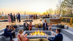 A deck with outdoor seating, a fire pit, and a view of the sunset. - 14k sq ft Mountaintop Estate - Private Golf Course (Fletcher)