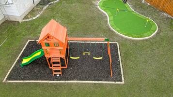 Ein Spielbereich für Kinder mit Rutsche und Schaukeln.