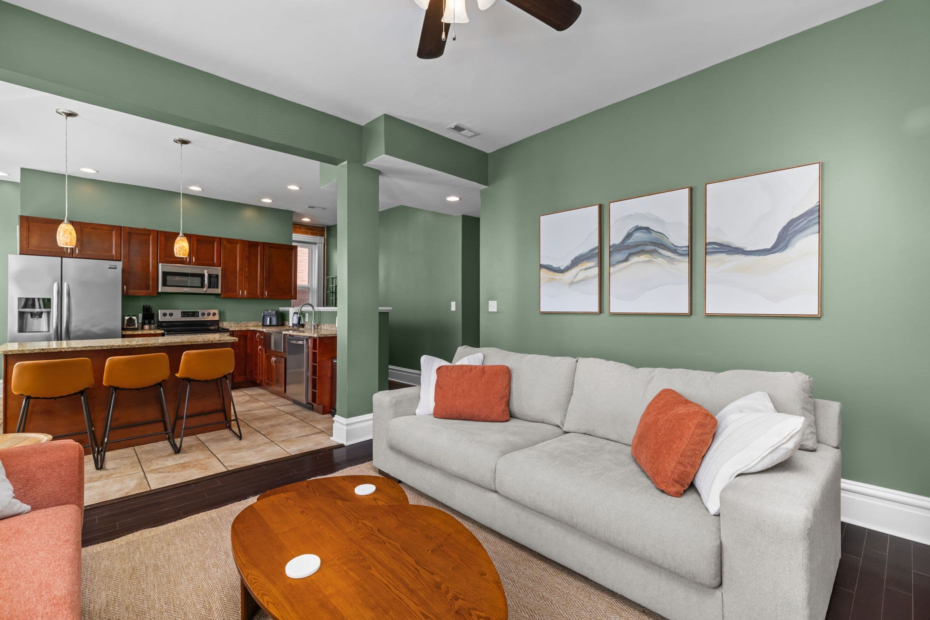 A modern living room with a grey sofa, orange cushions, and a wooden coffee table.
