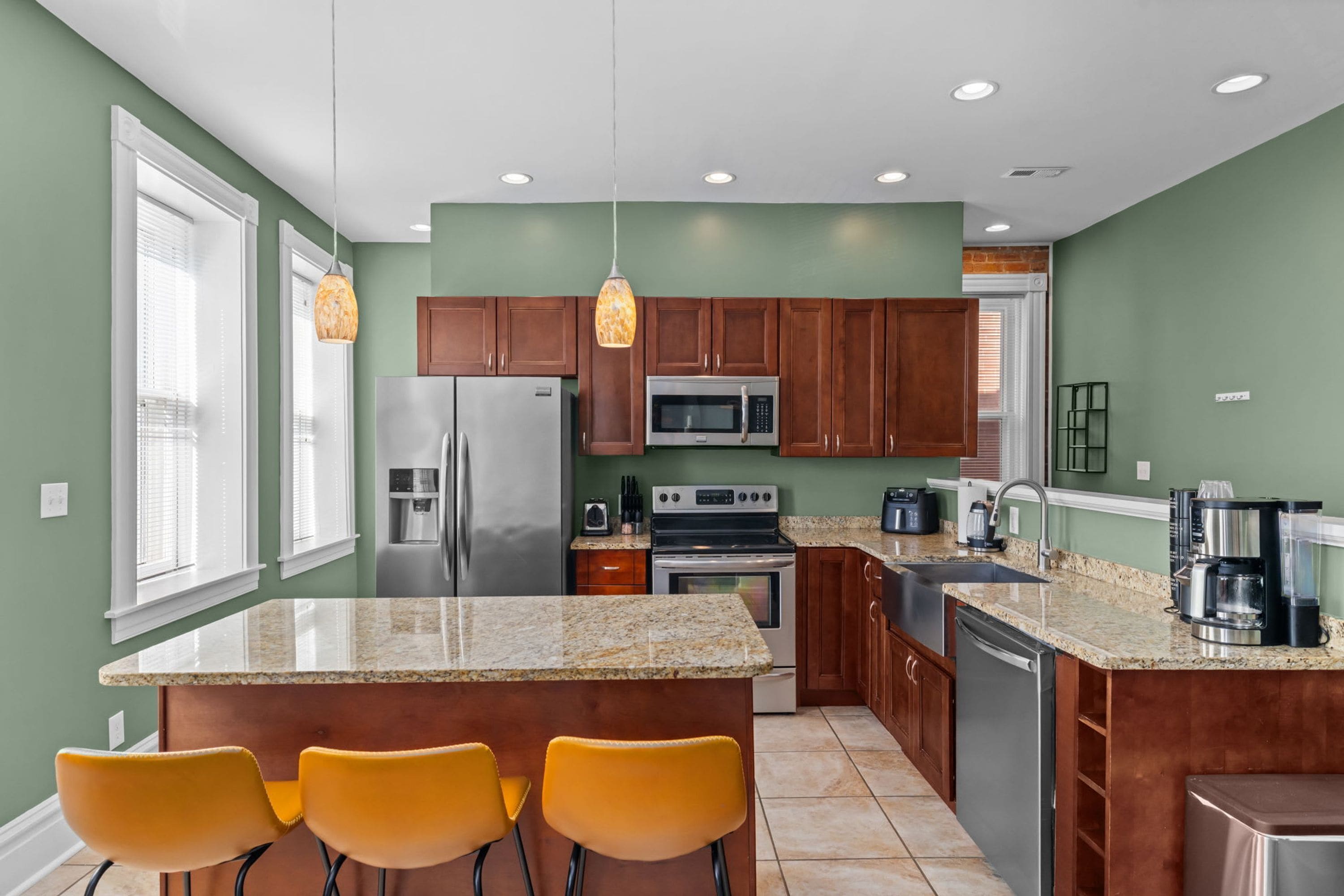 A modern kitchen with granite countertops, stainless steel appliances, and wooden cabinets.
