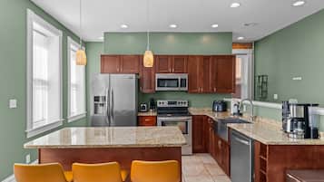 A modern kitchen with granite countertops, stainless steel appliances, and wooden cabinets.